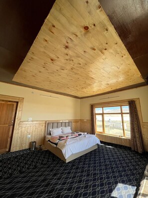 Relax in this cozy retreat with a large bed and window view.