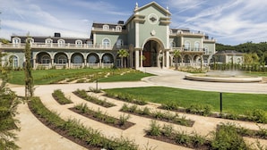 A large, historic building with a grand entrance, a fountain, and a well-maintained garden with pathways. - Amoure Hotel (Vila Verde)