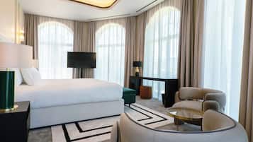 Una habitación de hotel moderna con cama, televisor, escritorio, silla y sofá.