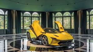 A yellow sports car in a spacious room with large arched windows and a polished floor. - Amoure Hotel (Vila Verde)