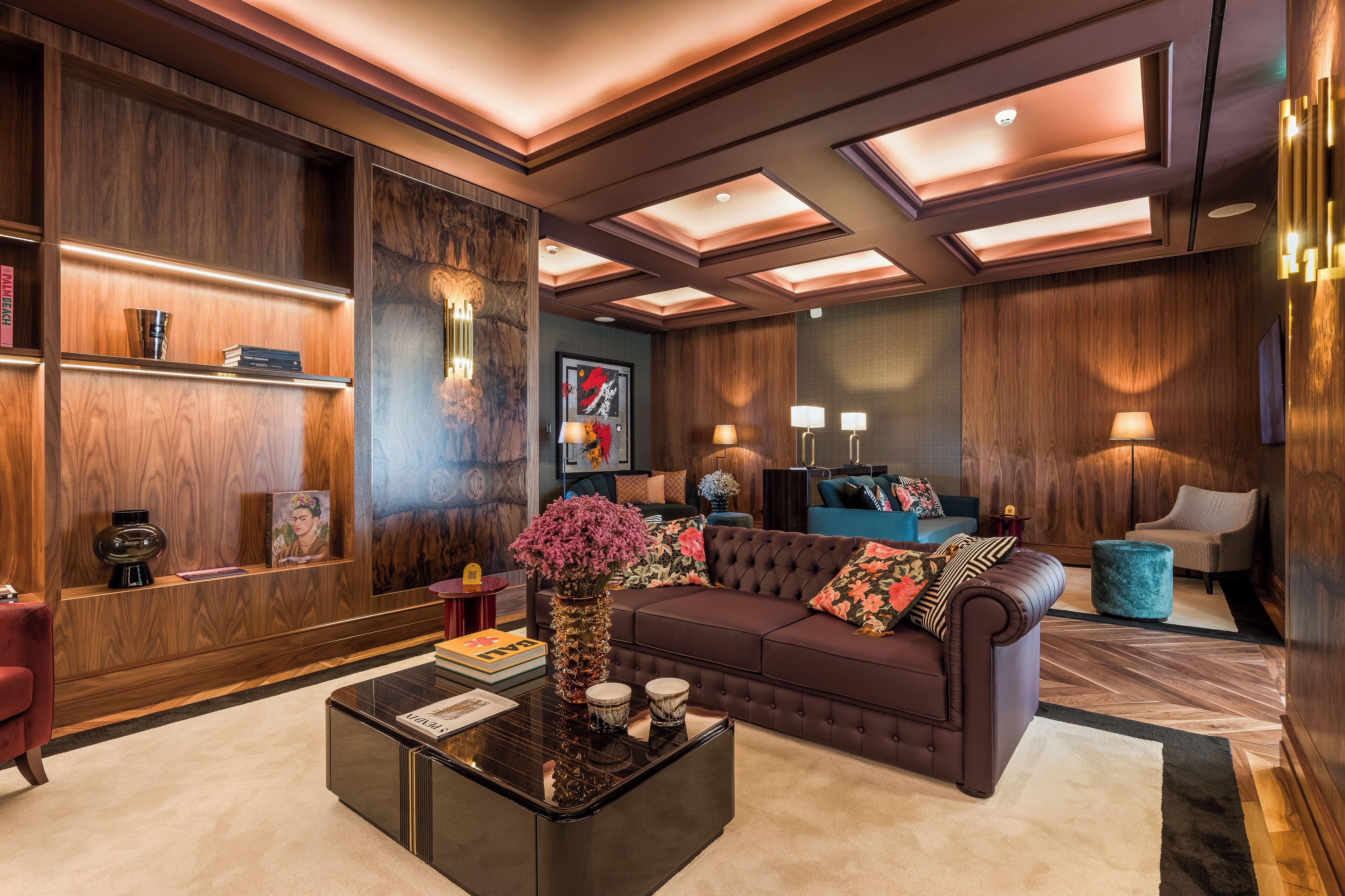 A modern living room with a brown sofa, a coffee table, and a bookshelf.