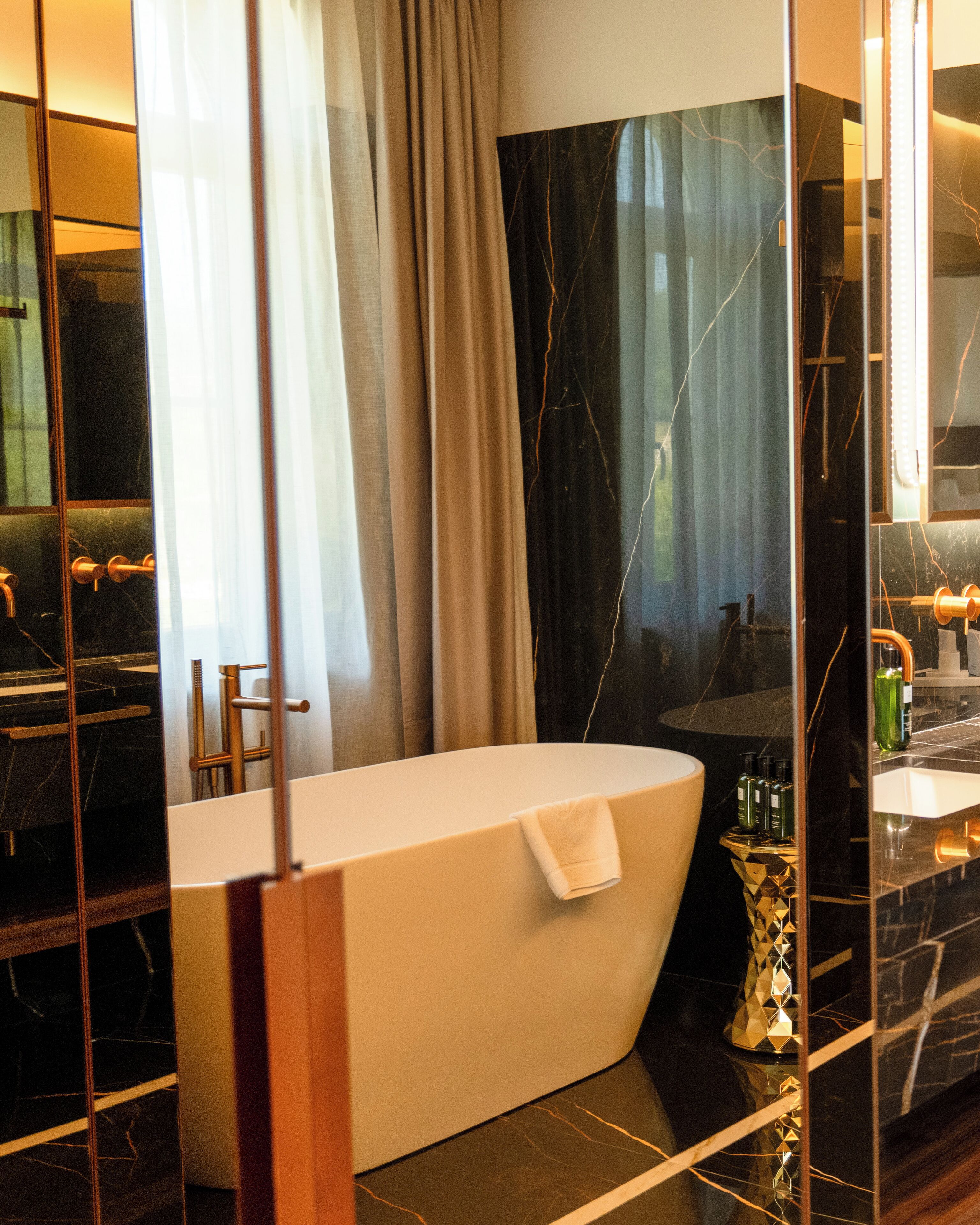 A modern bathroom with a freestanding bathtub, a vanity with a mirror, and a glass-enclosed shower area.
