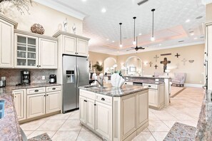 A spacious kitchen with a central island, built-in appliances, and a dining area with a chandelier.
