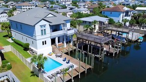 A large house with a pool, dock, and waterfront view. - Waterfront Home w/ Pool, Boat Slip & Private Beach Access – Holiday Isle (Destin)