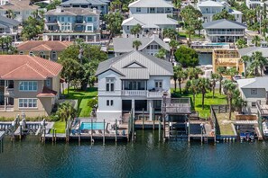 A waterfront property with a dock, a swimming pool, and multiple houses.