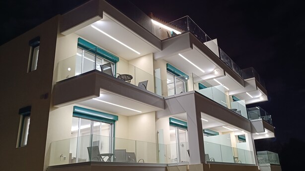 A multi-story building with balconies, large windows, and modern architectural design. - AIR IN ROOMS (Spata-Artemida)