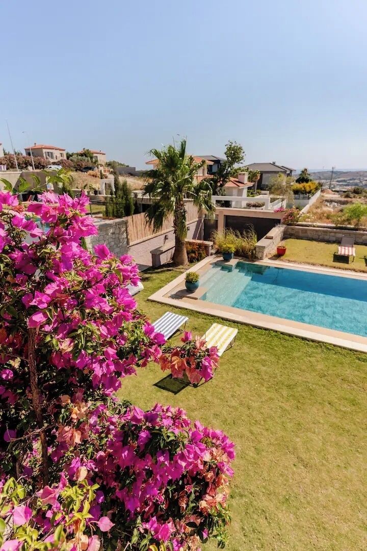 Una propiedad residencial con piscina, césped cuidado y vistas del vecindario circundante.
