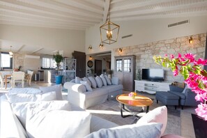 Un salón amplio con un conjunto de sofás, una mesa de centro y un televisor.