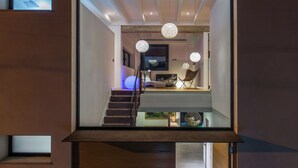 A modern interior with a staircase leading to a loft area, a dining table, and a chair. - Villa O2 - beautiful property in Alcudia (Alcudia)