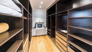 A walk-in closet with wooden shelving, a radiator, and a small display unit. - Villa Panoramica - modern villa in Alcudia (Alcudia)