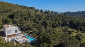A modern house with a swimming pool, surrounded by dense forest and hills. - Villa Sky - private swimming pool and terrace (Alcudia)