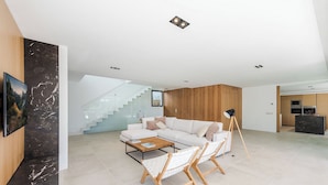 A modern living room with a white sofa, a coffee table, and a floor lamp. - Villa Sky - private swimming pool and terrace (Alcudia)