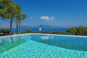 A clear blue pool with a view of the sea and mountains in the background. - Villa Seablue - gorgeous sea view front line (Alcudia)