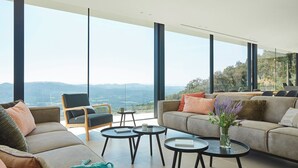 Een moderne woonkamer met een groot raam dat een panoramisch uitzicht geeft op het landschap.