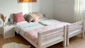 Une chambre à coucher avec un lit en bois, des tables de chevet blanches et un tapis blanc.