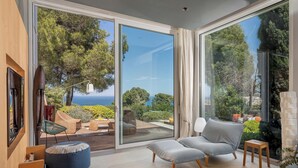 Ein modernes Wohnzimmer mit einem großen Schiebeglastür, die auf eine Terrasse im Freien führt.
