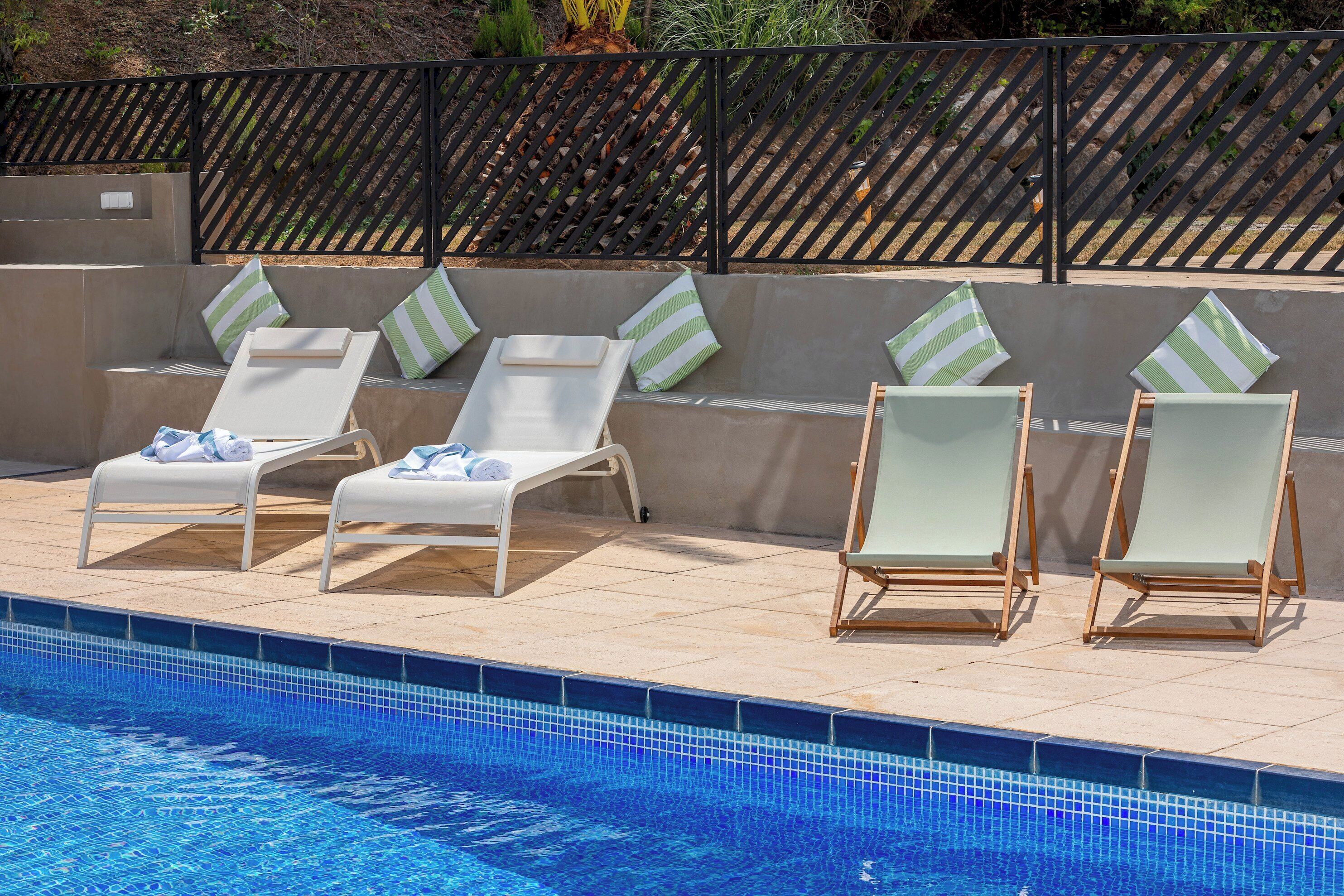 A poolside area with lounge chairs and a tiled pool.