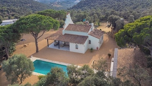A white villa with a tiled roof, a swimming pool, and a patio area surrounded by trees. - Casa La Capella - Lovely property with pool in Costa Brava (Girona)