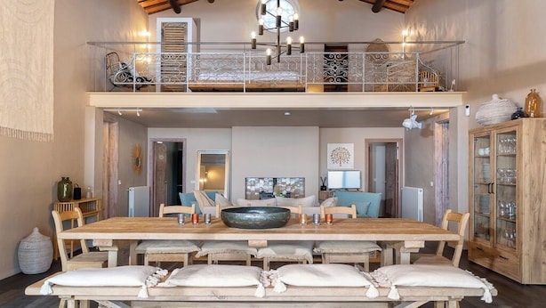 A spacious dining area with a large wooden table, multiple chairs, and a decorative bowl centerpiece. - Casa La Capella - Lovely property with pool in Costa Brava (Girona)