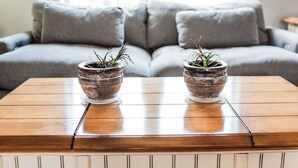 A wooden coffee table with two ceramic pots on it, placed in front of a grey sofa with cushions. - G's: Pet friendly: Firepit: King bed: Walk2town (Boyne City)