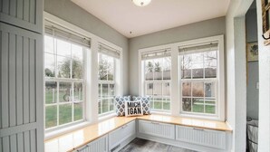 A room with large windows, a built-in bench, and a radiator. - G's: Pet friendly: Firepit: King bed: Walk2town (Boyne City)