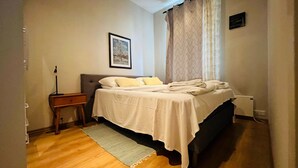 Une chambre à coucher avec un lit, une table de chevet et un tableau encadré accroché au mur.
