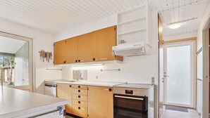 Une cuisine moderne avec des meubles en bois, un four encastré et un lave-vaisselle.