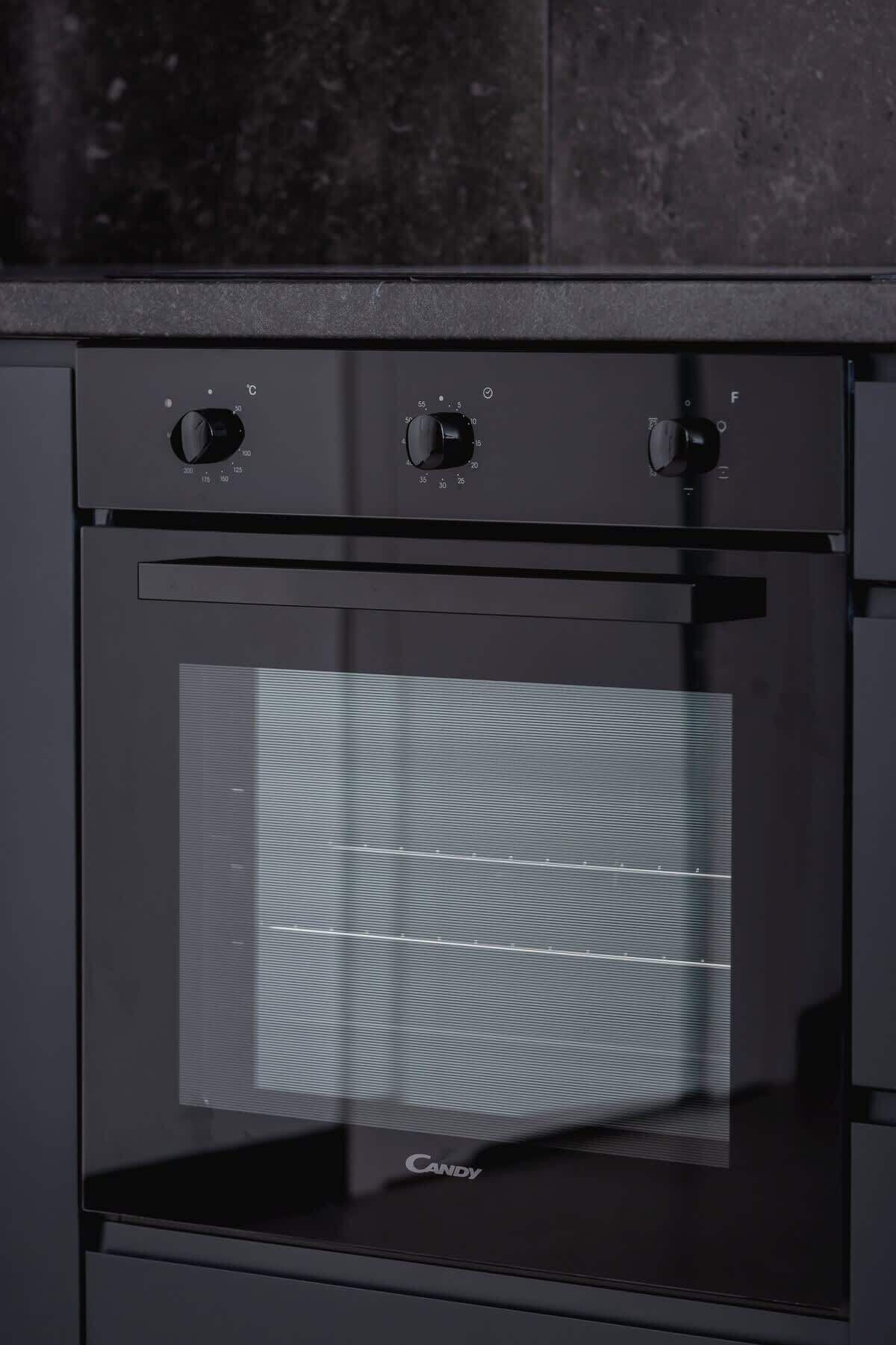 A black oven with three control knobs and a glass door.