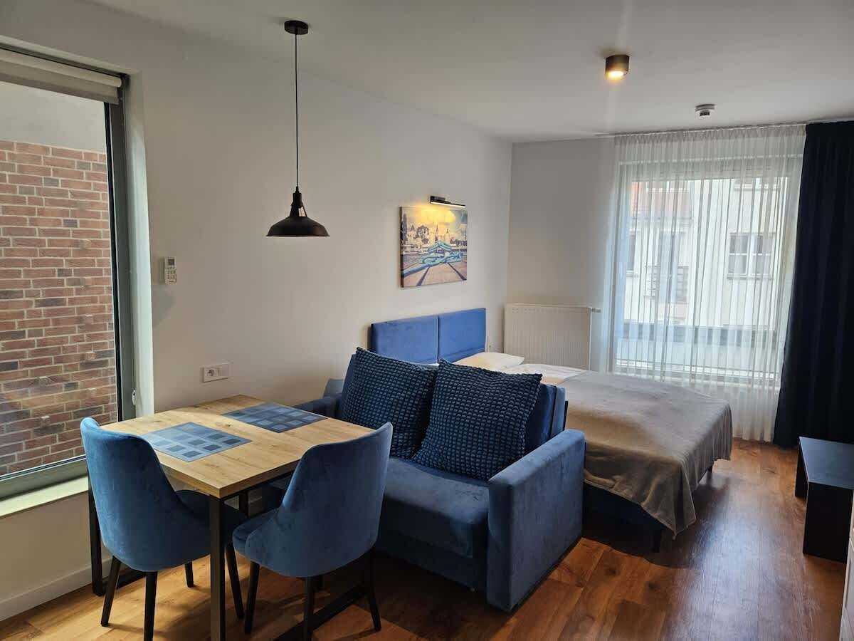 Studio with a double bed, single sofa, TV and dining area.