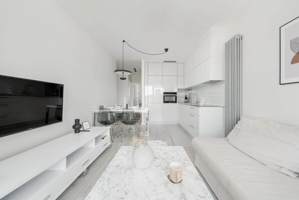 A modern living room with a TV, sofa, and coffee table.