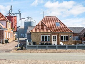 A small brick building with a red-tiled roof, a white fence, and a gravel driveway. - 6 Person Holiday Home in Hojer (Højer)