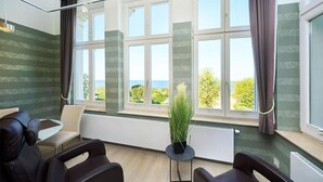 A room with a view of the sea, a massage chair, a small table with a plant, and a radiator. - Strandvillen Wald & See (Zinnowitz)