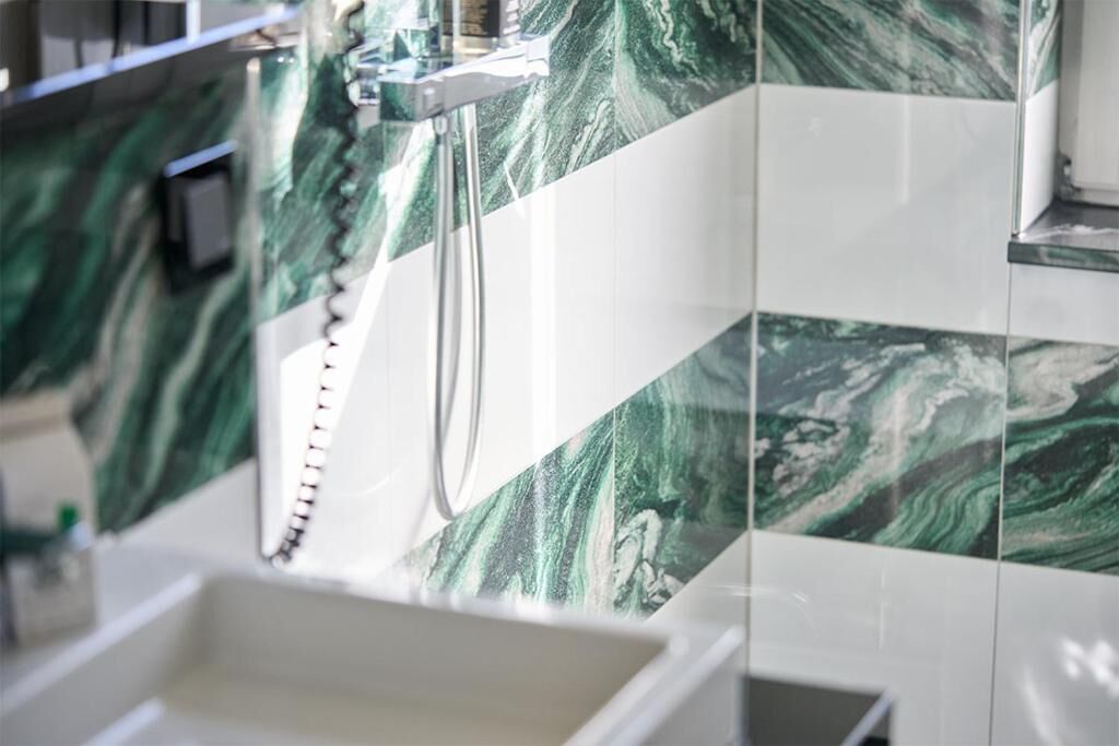 Un baño con salpicadero de mármol y zona de ducha.