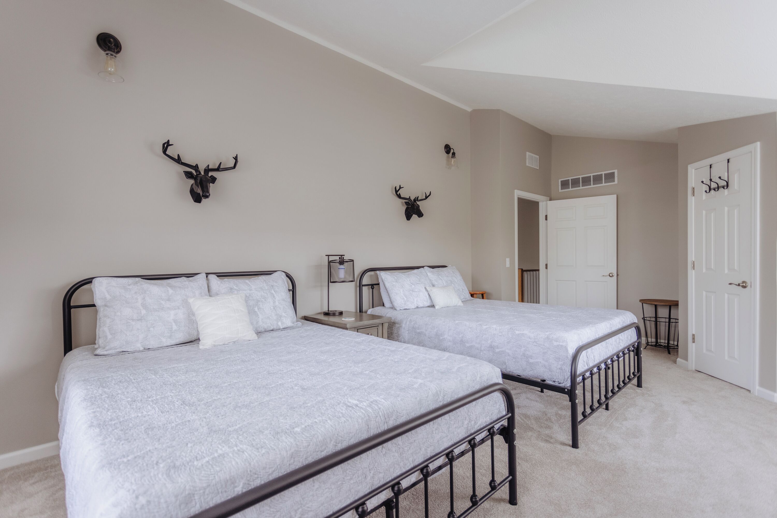 Un dormitorio con dos camas, una puerta y decoración en la pared.
