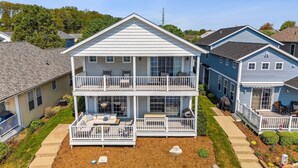 A two-story house with a balcony, a covered patio, and a well-maintained lawn. - On The River, Assn Pool & Hot Tub, Water Taxi in Summer (St. Joseph)