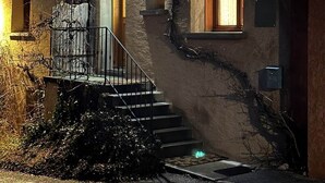 Un bâtiment doté d’une façade en pierre, d’un escalier en bois et d’une petite fenêtre.