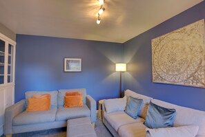 Ein Wohnzimmer mit zwei Sofas, einer Stehlampe und einem großen Wandbild.