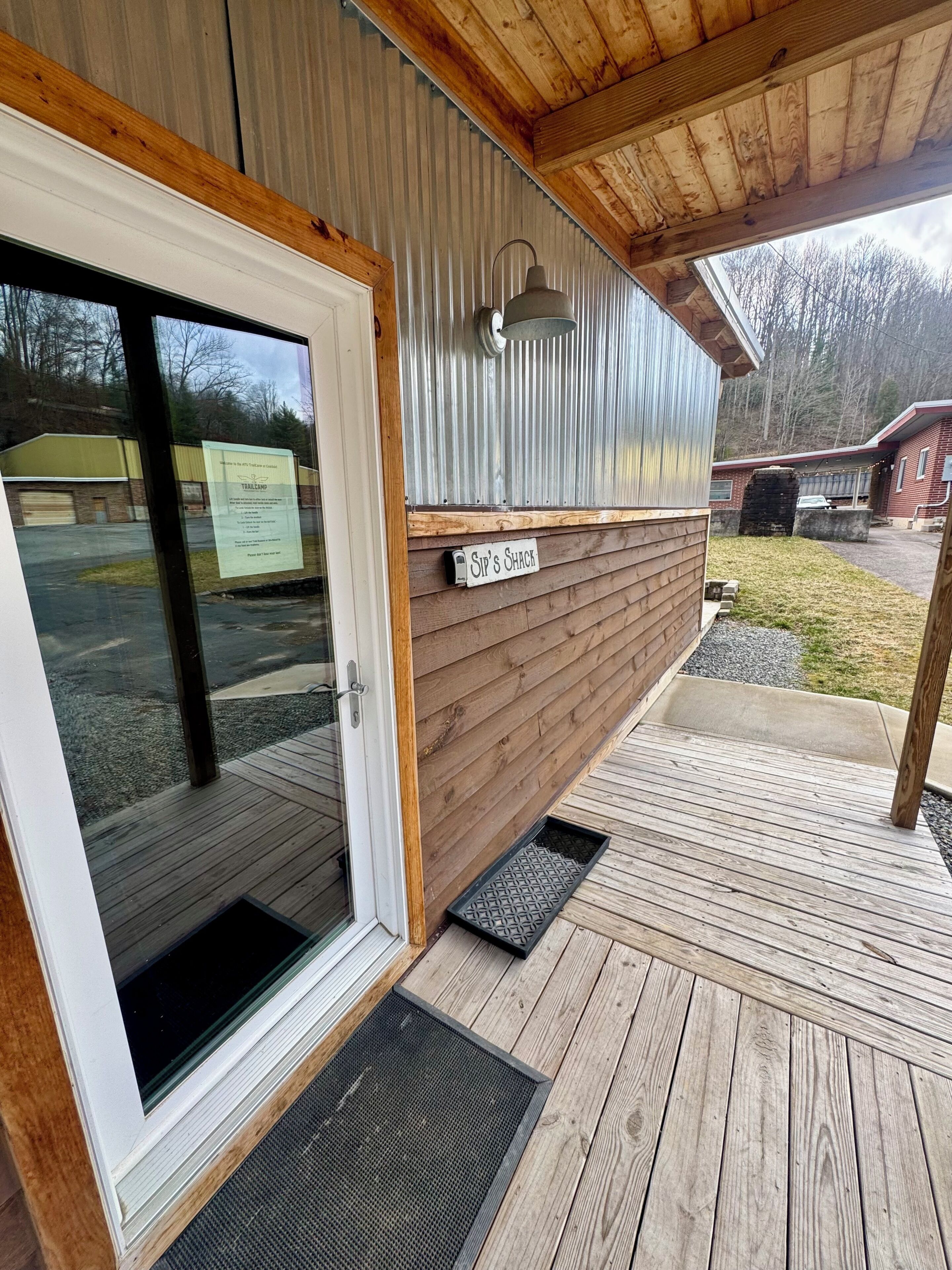 A wooden exterior with a metal roof, a glass door, and a sign reading 'Sip's Shack.'