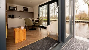 Une cuisine moderne équipée d’un four à micro-ondes, d’une machine à café et d’un coin repas avec des chaises et une table.