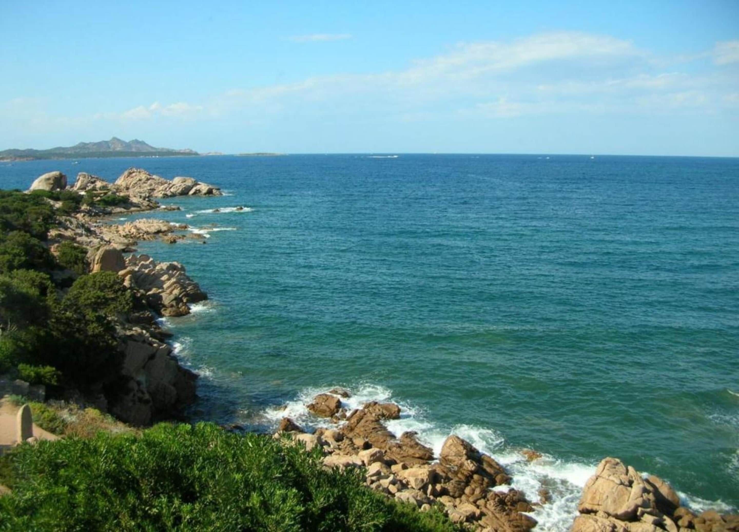 A coastal landscape with rocky terrain and a view of the sea.