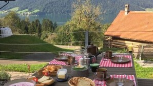 A picnic setup with food and drinks on a table, overlooking a mountainous landscape. - Farm in the Agerital (Oberaegeri)