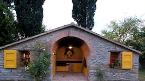 A stone building with a central arched entrance, yellow shutters, and a small porch area. - Spacious Holiday Home in Brisighella (Brisighella)