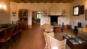 A rustic interior with a dining area, wicker chairs, a fireplace, and a cozy seating area. - Spacious Holiday Home in Brisighella (Brisighella)