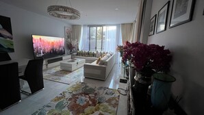 A modern living room with a flat-screen TV, a sofa, a coffee table, and a decorative rug. - Centre of town  (Sydney)