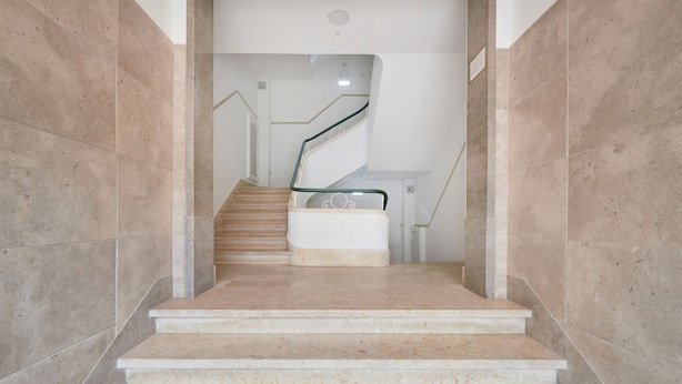 A staircase with marble steps and a glass railing leading to a landing. - Light Filled & Renovated Apartment, By Timecooler (Lisbon)