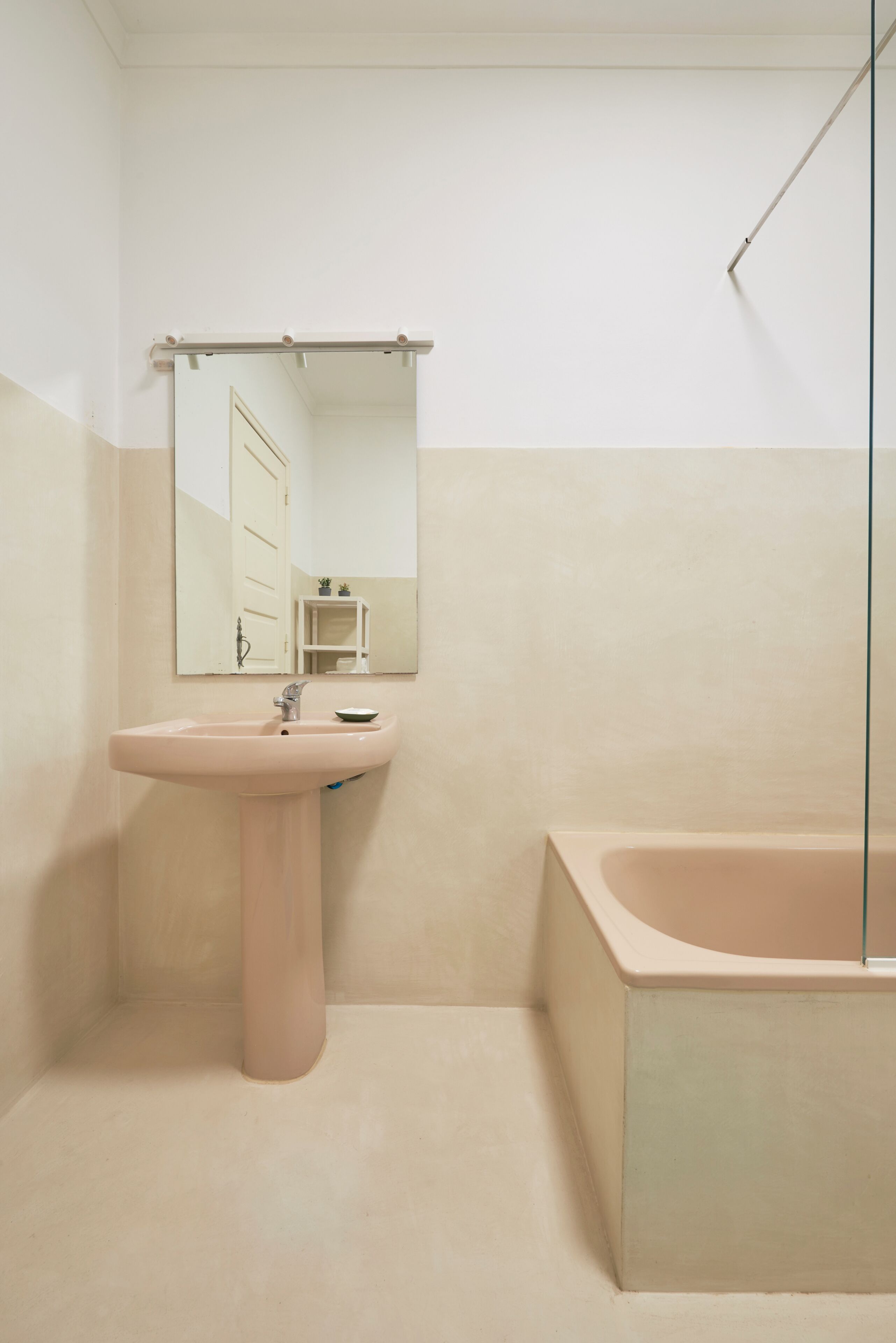 Ein Badezimmer mit Waschbecken, Spiegel und Badewanne.