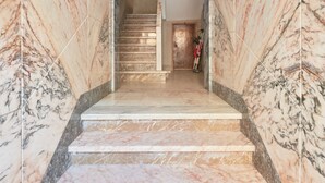 A marble staircase leading to a room with a door at the top. - Central & Sunny 2Br Apt Near Beach, By Timecooler (Setubal)