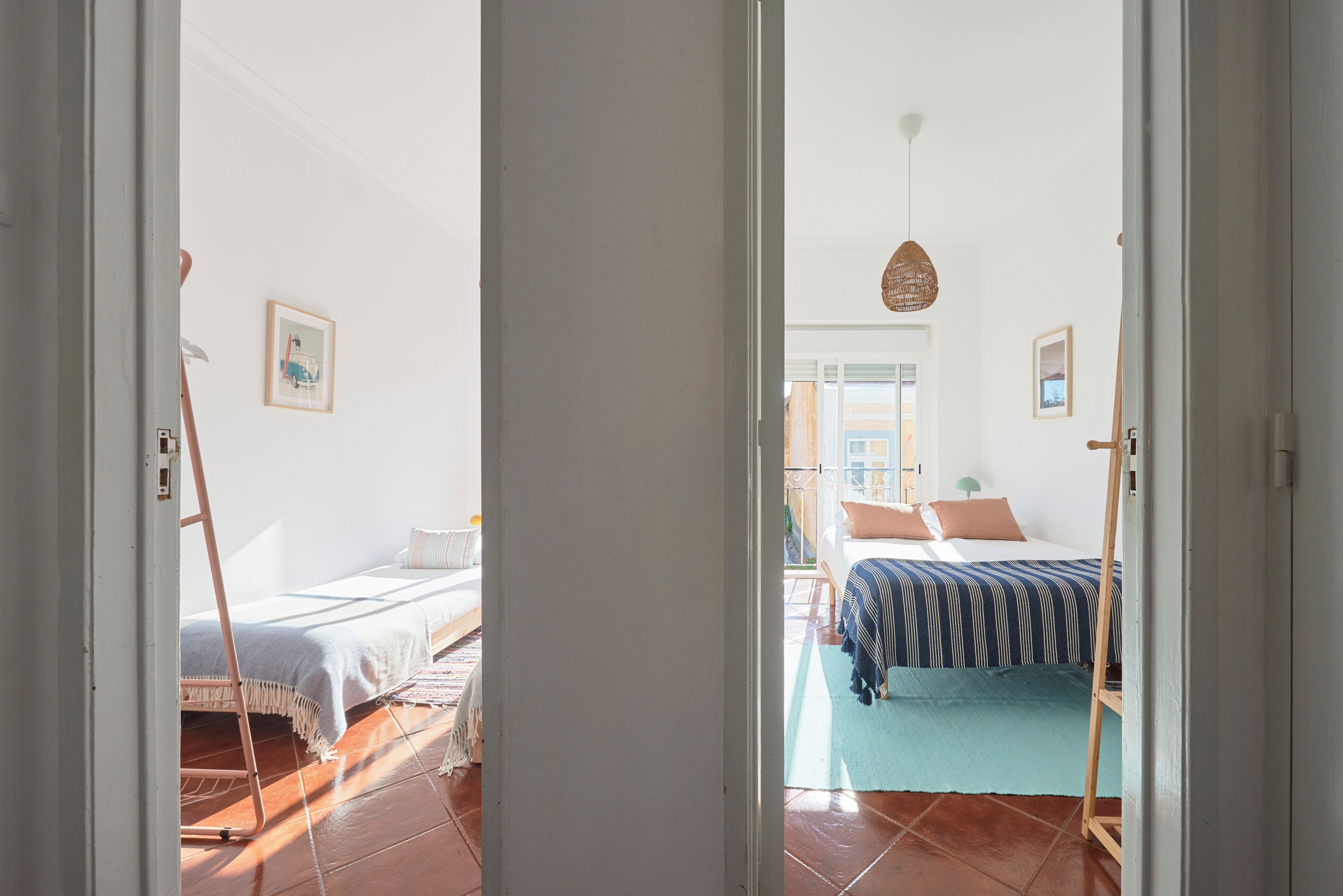 Ein Zimmer mit einem Bett, einer Holzleiter und einer Tür zu einem anderen Raum.