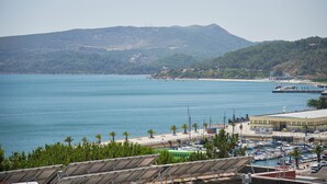 A marina with boats, a building with a flat roof, and a mountainous backdrop. - Sunset Bay View Renovated Apt, By Timecooler (Setubal)