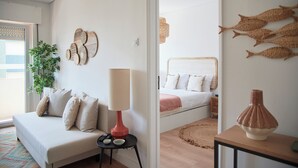 A modern bedroom with a bed, bedside table, lamp, and decorative wall art. - Sunset Bay View Renovated Apt, By Timecooler (Setubal)